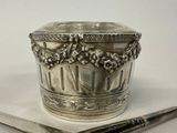 a silver container with a spoon and a knife on a table
