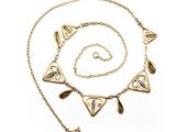 a close up of a necklace and bracelet on a white background