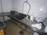 une cuisine avec un évier et beaucoup de vaisselle sur le plan de travail
