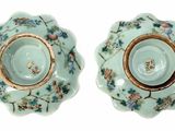 pair of porcelain dishes with floral designs on them on a white surface