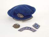 a blue hat and some pins on a white surface