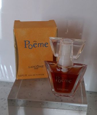 un flacon de parfum posé sur une table à côté d'une boîte de parfum