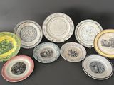 seven plates with different designs on them sitting on a black surface