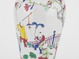 un vase blanc orné de motifs colorés, posé sur un socle en bois