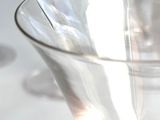 a glass bowl sitting on a table with wine glasses in the background
