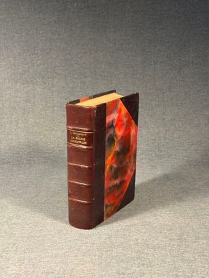 an old book sitting on top of a table next to a glass bottle