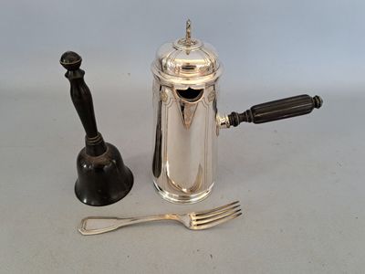 une cafetière en argent à côté d'une fourchette et d'une cuillère