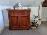un petit meuble en bois avec un lavabo, dans un coin de la pièce