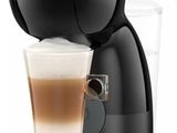 gros plan d'une tasse de café à côté d'une cafetière