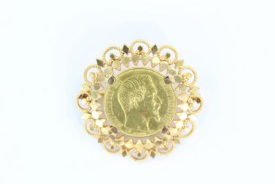 une image représentant une broche en or avec une pièce de monnaie au centre