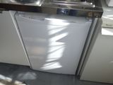 a white dishwasher sitting in a kitchen next to a sink