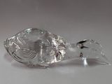 une figurine d'oiseau en verre transparent posée sur une surface blanche