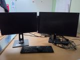 two computer monitors sitting on a desk with a keyboard and mouse