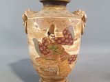 a vase with a painting on it sitting on a table