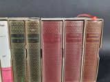 several old books are lined up in a row on a table