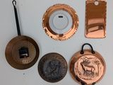 a lot of copper pots and pans on the table