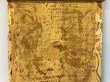 an old wooden box with gold paint on it sitting on a white surface