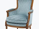 une chaise rembourrée dont l'assise est recouverte d'un tissu bleu