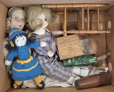 deux poupées dans une boîte en carton, avec une échelle en arrière-plan