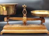 une balance en or posée sur une table, avec deux coupelles dessus