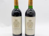 deux bouteilles de vin posées l'une à côté de l'autre sur une surface blanche