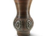 un vase brun posé sur une surface blanche