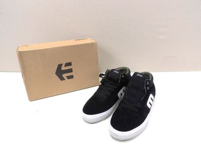 a pair of black and white shoes next to a box