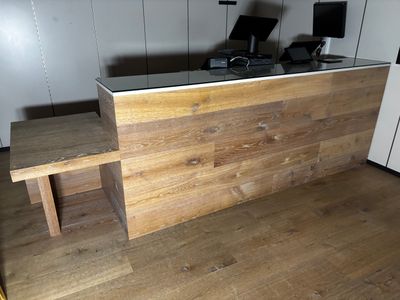 un comptoir en bois avec un plateau en verre dans une pièce