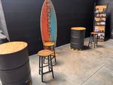 three stools and a surfboard in a room