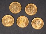 quatre types différents de pièces d'or sur une surface noire