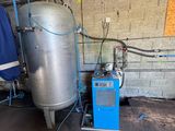 un grand réservoir situé à côté d'une machine bleue