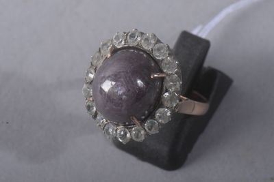 an image of a close up of a ring with a purple stone on it