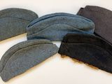 Plusieurs chapeaux sont alignés sur une surface blanche