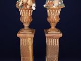 pair of carved wooden vases with fruit and vegetables in them