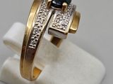 a close up of a gold ring with a black stone on it