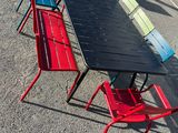 a long table and four red chairs in the parking lot