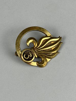 une image représentant une broche en or ornée d'une feuille