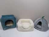 three dog beds and a cat bed on a shelf