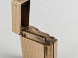 an image of a gold cigarette case sitting on top of a white surface