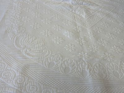 une photo d'un lit recouvert d'un couvre-lit blanc