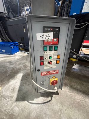 un gros plan d'une machine dans un entrepôt, sur laquelle est accrochée une pancarte