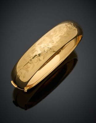 gros plan d'une bague en or sur une surface noire