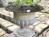 a stone planter sitting on the steps outside of a building