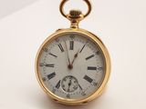 une montre de poche en or avec des chiffres romains sur le cadran