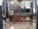 un miroir au milieu d'une pièce, avec une personne à l'arrière-plan