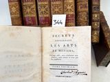 un vieux livre posé sur une table à côté d'une pile de livres