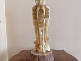 une statue représentant un homme et une femme posée sur une table en bois