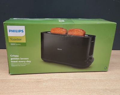 un grille-pain Philips contenant deux tranches de pain, posé sur une table