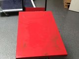 a red table on a dolly cart in a warehouse