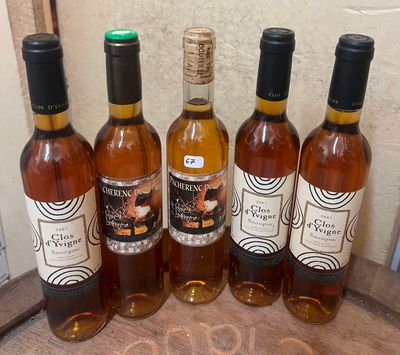 plusieurs bouteilles de vin sont alignées sur un plateau en bois